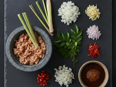Udang kering ditumbuk bersama serai, bawang cincang, bawang besar dadu, daun kari, cili padi dan mangkuk bancuhan sos kari disusun sedia untuk ditumis