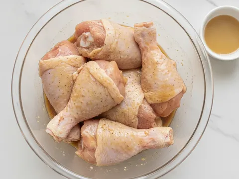 Ketul ayam digaul dengan kicap cair dan lada putih dalam mangkuk untuk diperap