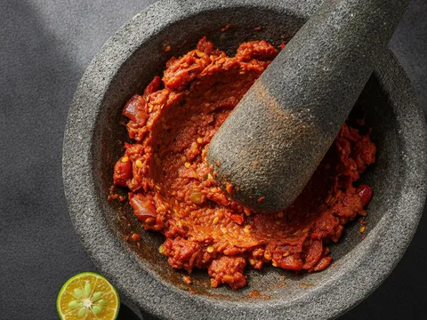 Sambal belacan merah ditumbuk kasar dalam lesung batu sehingga sebati dan bertekstur