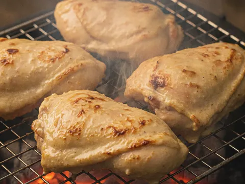 Ayam percik dengan lapisan kuah santan berkrim dan tompok rentung keperangan sedang dibakar