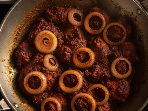 Bawang besar hiris ditambah ke dalam ayam sambal dan dikacau sehingga layu sebelum dihidang