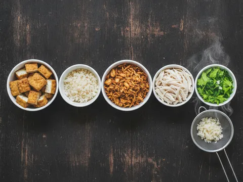 Tauhu goreng dadu, lobak masin cincang, bawang goreng dan hirisan daun sup disusun dalam mangkuk berasingan
