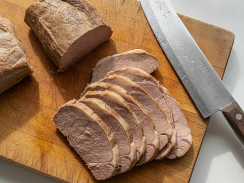 Daging lembu rebus dihiris setebal 1cm melintang urat di atas papan pemotong kayu