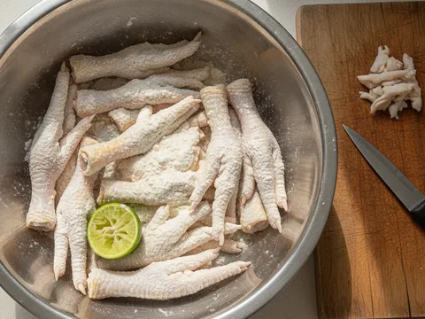 Kaki ayam dipotong buang kuku dan disental dengan tepung gandum dalam besen sebelum dibilas