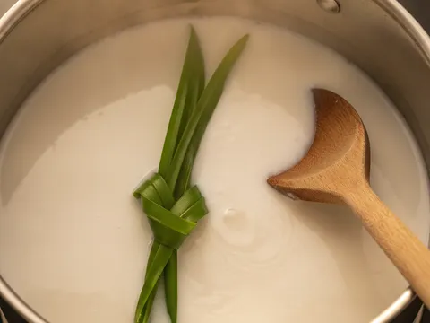 Santan bersama daun pandan dimasak perlahan dalam periuk sehingga panas berwap