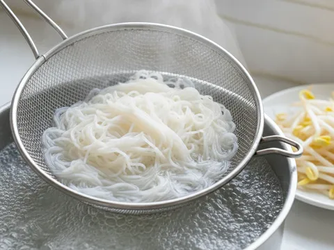 Beehoon dicelur dalam air mendidih menggunakan penapis dawai