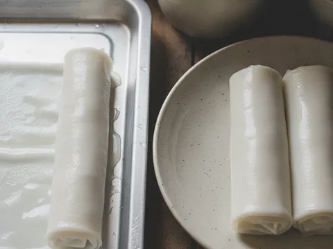 Kepingan laksam lut sinar digulung kemas menjadi gulungan putih lembut di atas dulang