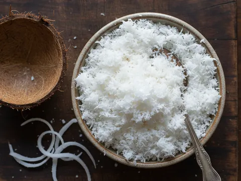 Kelapa parut putih digaul dengan garam dalam mangkuk kecil sebagai inti lepat pisang