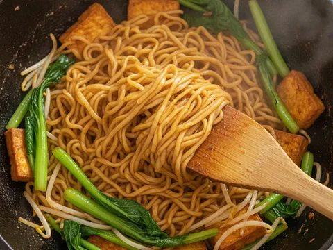 Sawi hijau, taugeh dan tauhu goreng digaul bersama mee maggi dalam kuali