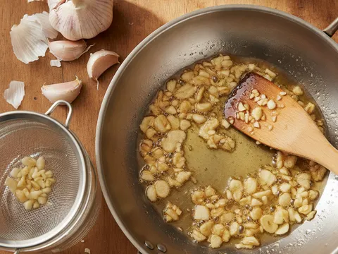Bawang putih cincang digoreng dalam minyak cetek sehingga baru bertukar kekuningan, sedia untuk ditapis