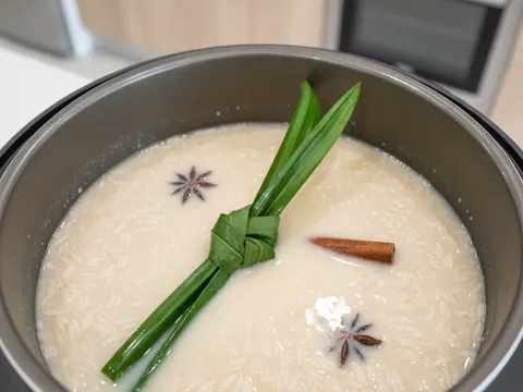 Beras berempah dimasak dalam periuk nasi bersama susu cair dan daun pandan