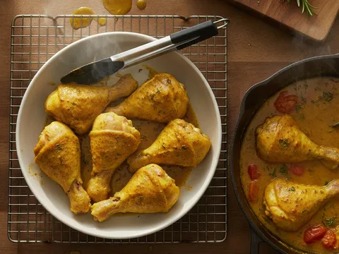 Enam ketul ayam berempah diangkat ke dalam mangkuk manakala dua ketul kekal dalam periuk rempah