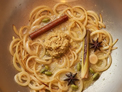 Bawang hiris dan tumbukan halia ditumis keemasan bersama rempah dalam kuali