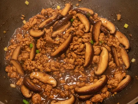 Cendawan shiitake dan ayam cincang ditumis dengan kicap sehingga pekat berkilat