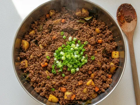 Inti samosa kentang dan daging berempah kari yang sudah kering dalam mangkuk, sedia disejukkan