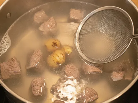 Daging lembu direneh perlahan bersama halia diketuk dalam periuk berisi air rebusan jernih